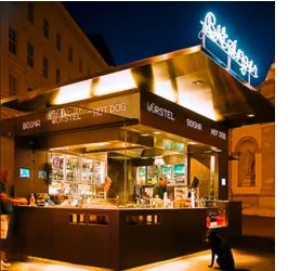 Imbiss-Pavillon mit Leuchtschrift am Abend